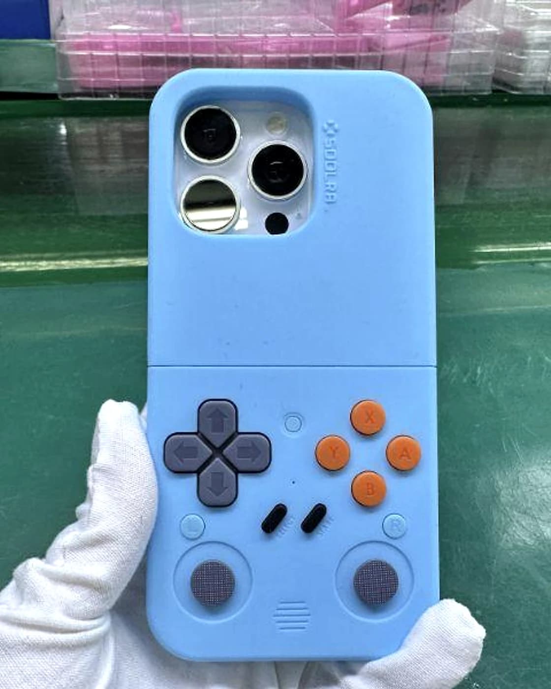 A finished blue SOOLRA™ controller case held with inspection gloves